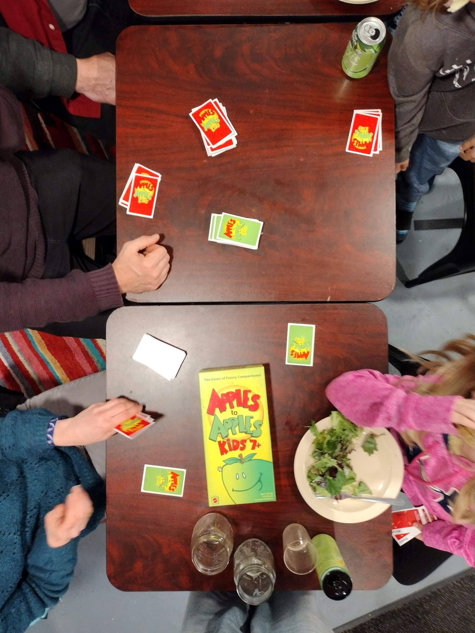 Table with Apples to Apples game cards on it